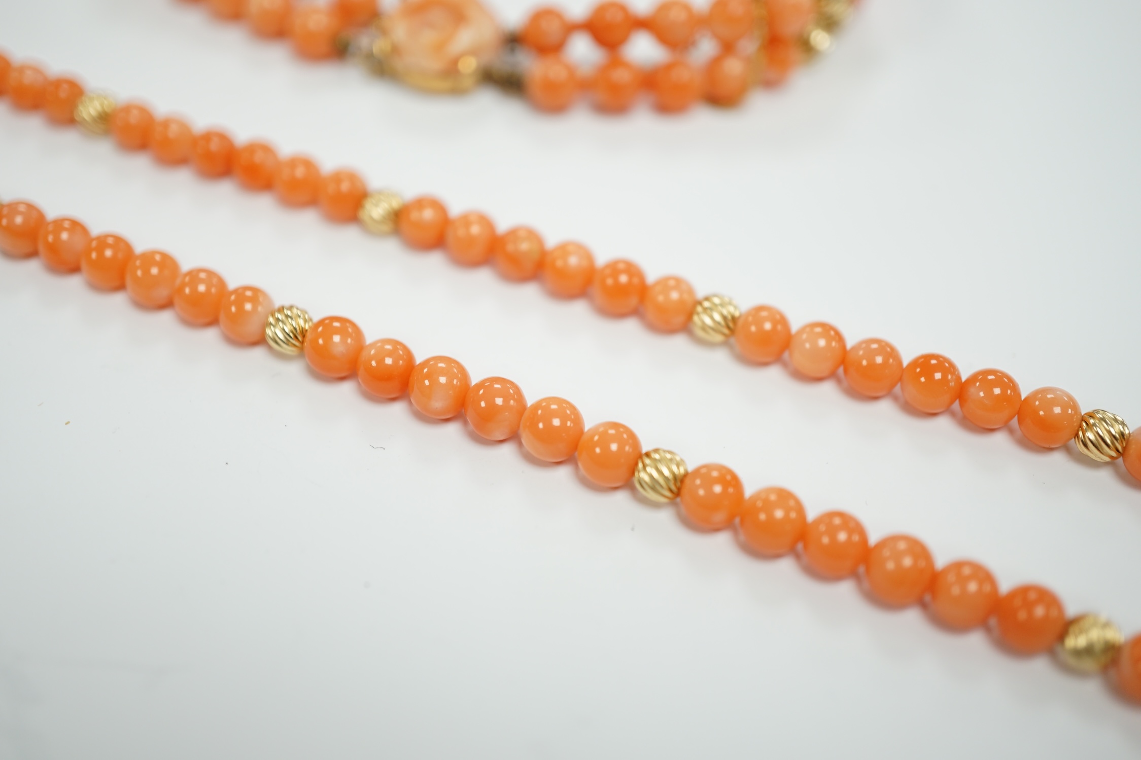 A modern 14k mounted twin strand coral bead necklace, 17cm, together with a 14k mounted single strand coral bead necklace, 44cm.